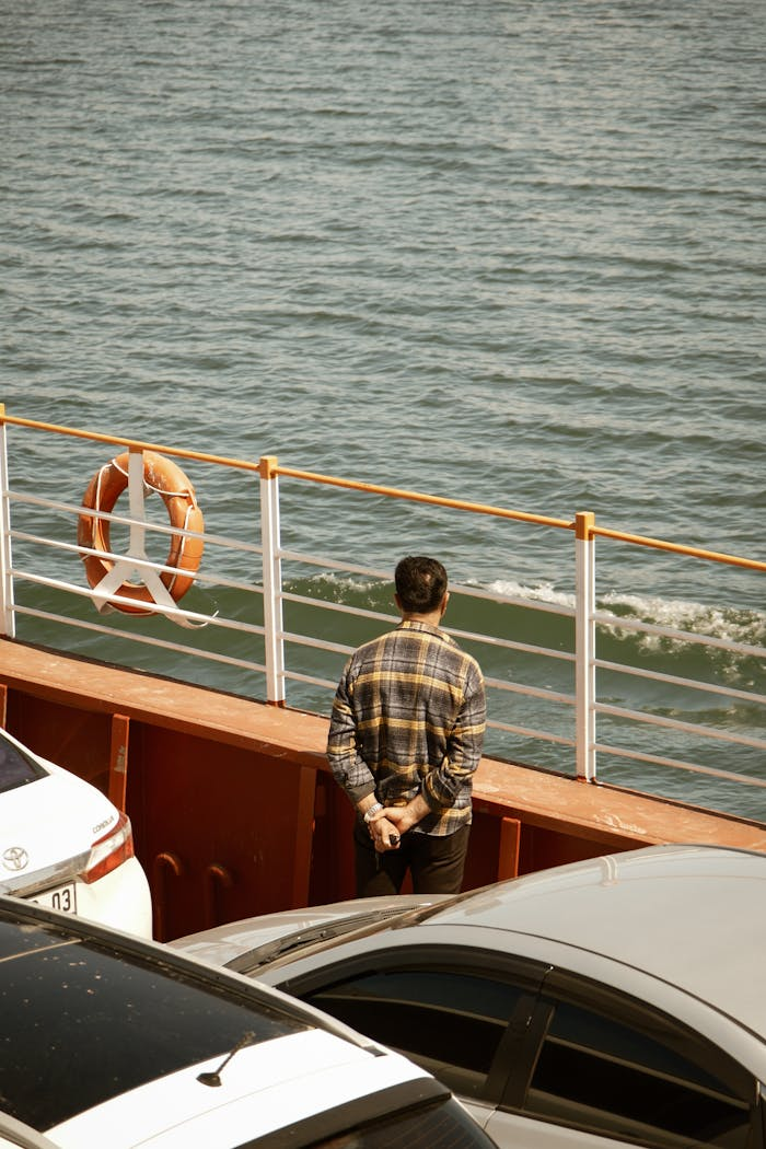 creative-03 A man in plaid shirt observing the ocean view from a ferry deck.